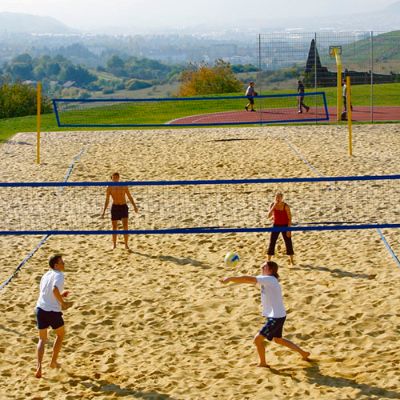 Vier Personen spielen Beachvolleyball