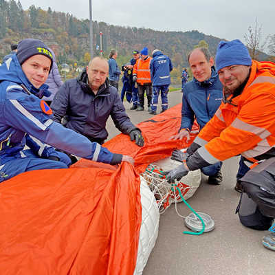 Julian Lehnart (THW, links), Alexander Hammel und Michael Eiden (StadtRaum Trier) erläutern Dezernent Dr. Thilo Becker (2. v. r.) die Funktionsweise des Mobildeichs, der am Zurlaubener Ufer auf einer Länge von 400 Metern ausgelegt wurde.