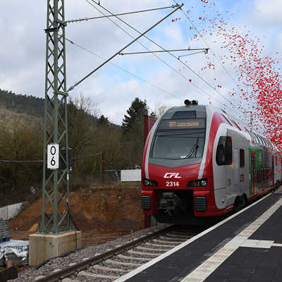 Der erste Zug fährt am neuen Bahnsteig an der Hafenstraße ein - noch ohne Fahrgäste, aber mit Konfetti.