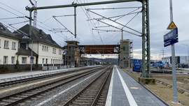 Haltepunkt an einer zweigleisigen elektrifizierten Bahnlinie mit Fußgängerbrücke über die Gleise