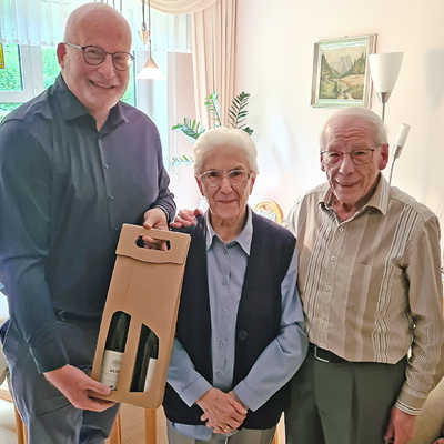 Der stellvertretende Ortsvorsteher Dirk Steffens (links) überreicht Herbert und Magdalena Selbach ein Weinpräsent zur eisernen Hochzeit. Foto: privat
