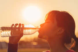 Eine Frau trinkt Wasser aus einer Flasche, 