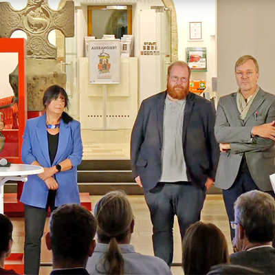 Baudezernent Dr. Thilo Becker, Sabine Borkam von der Stabsstelle Innenstadt und Kulturdezernent Markus Nöhl (v. l.) hören sich die unterschiedlichen Vorschläge der Bürgerinnen und Bürger an. Die Veranstaltung moderieren die beiden Architekten Fabrice Tesch (rechts) und Marcus Hille. Screenshot: OK54/nok