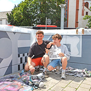 Unter der Aufsicht von Jugendbetreuer Dimo Rasch (links) gestalteten Jugendliche die Stromkästen am Viehmarkt neu. Der Entwurf für das Motiv wurde von Max Schwarz (rechts) gezeichnet.
