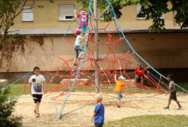 Kinder entdecken die Kletterspinne des neuen Spielplatzes Kinder entdecken die Kletterspinne des neuen Spielplatzes